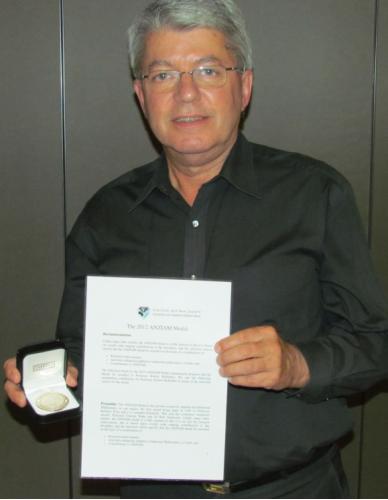 McKibbin holding medal and certificate